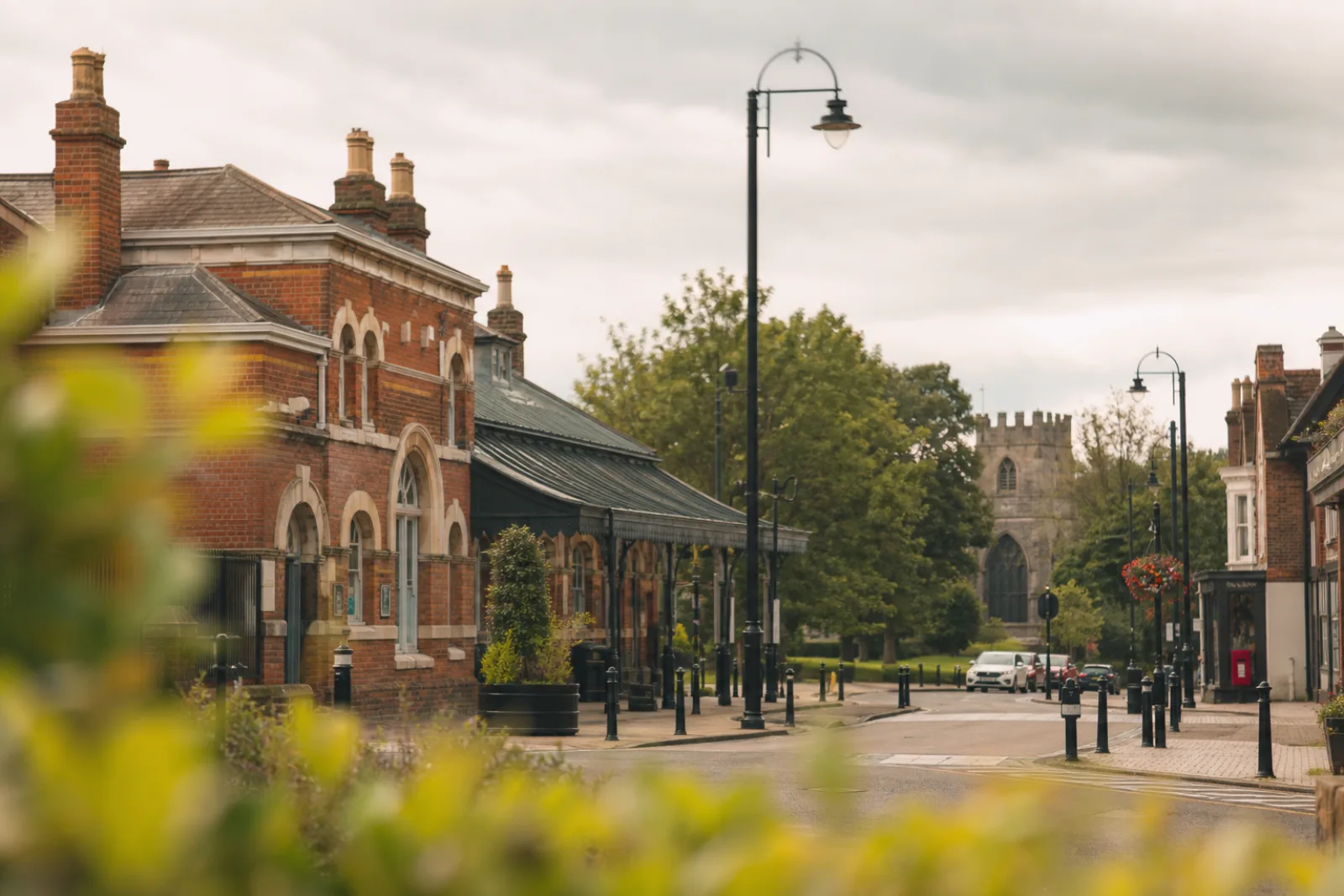 Victorian red-brick buildings on Ashford high street with the church tower beyond