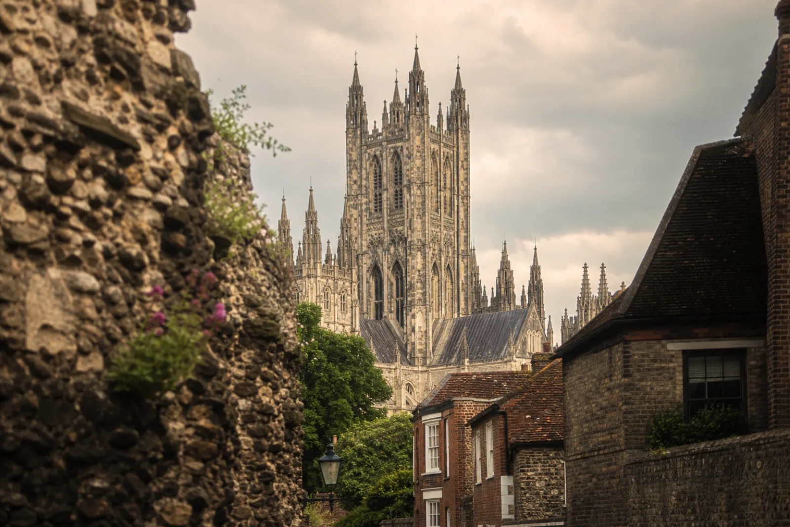Canterbury Cathedral towers rising above the old city wall and medieval rooftops